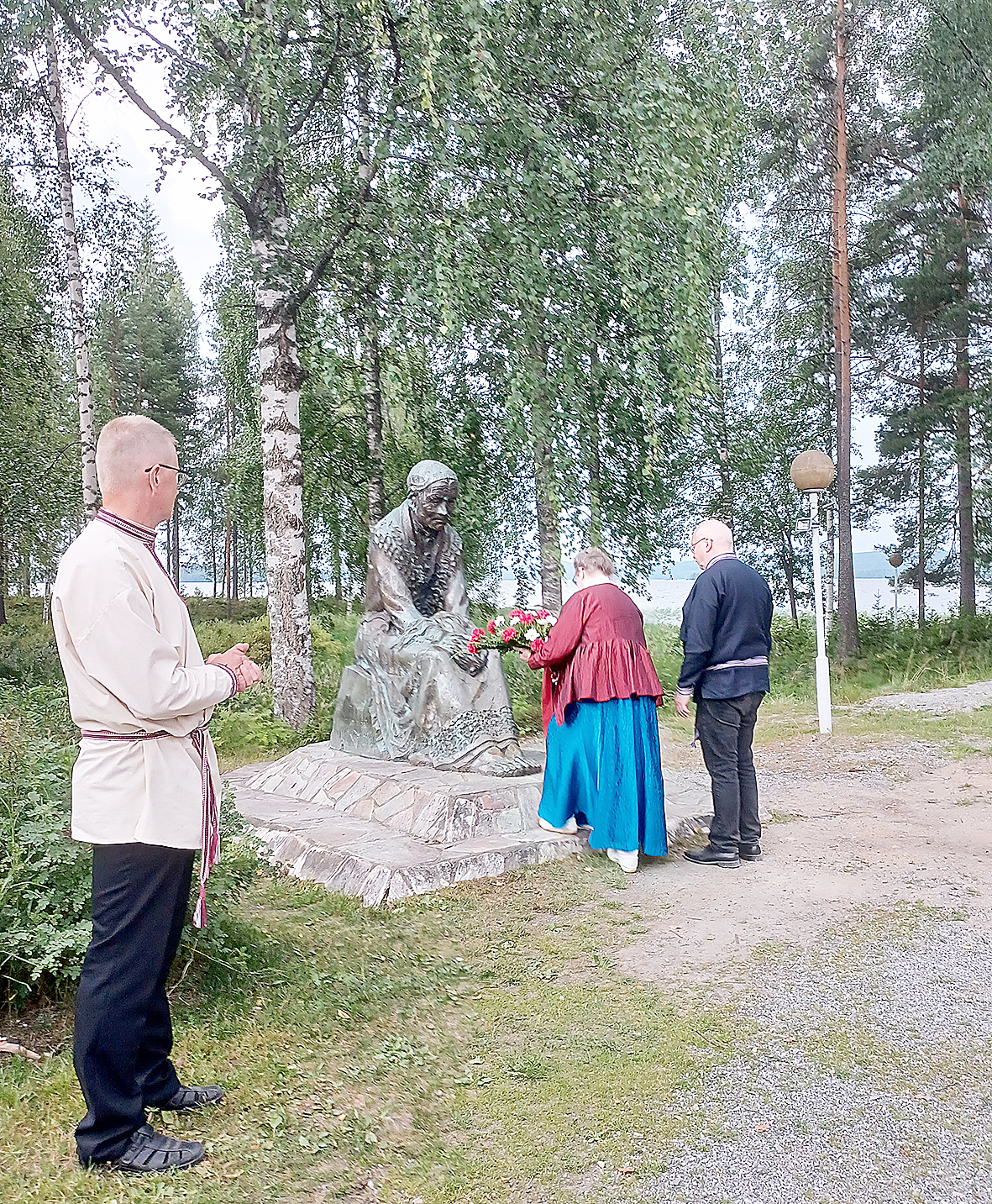 Runonlaulaja Ogoi Määräsen patsaan kukittivat Härkkimen sukuseuran puolesta Liisa Grudein ja Matti Tuomisto. Kukitusta seuraa Suojärven pitäjäseuran uusi puheenjohtaja Risto Salmela.