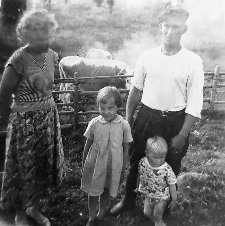 Aune ja Raimo Tenhunen vanhimpien lastensa Pirjon ja Jorman kanssa. Taustalla lehmät savuksella.
