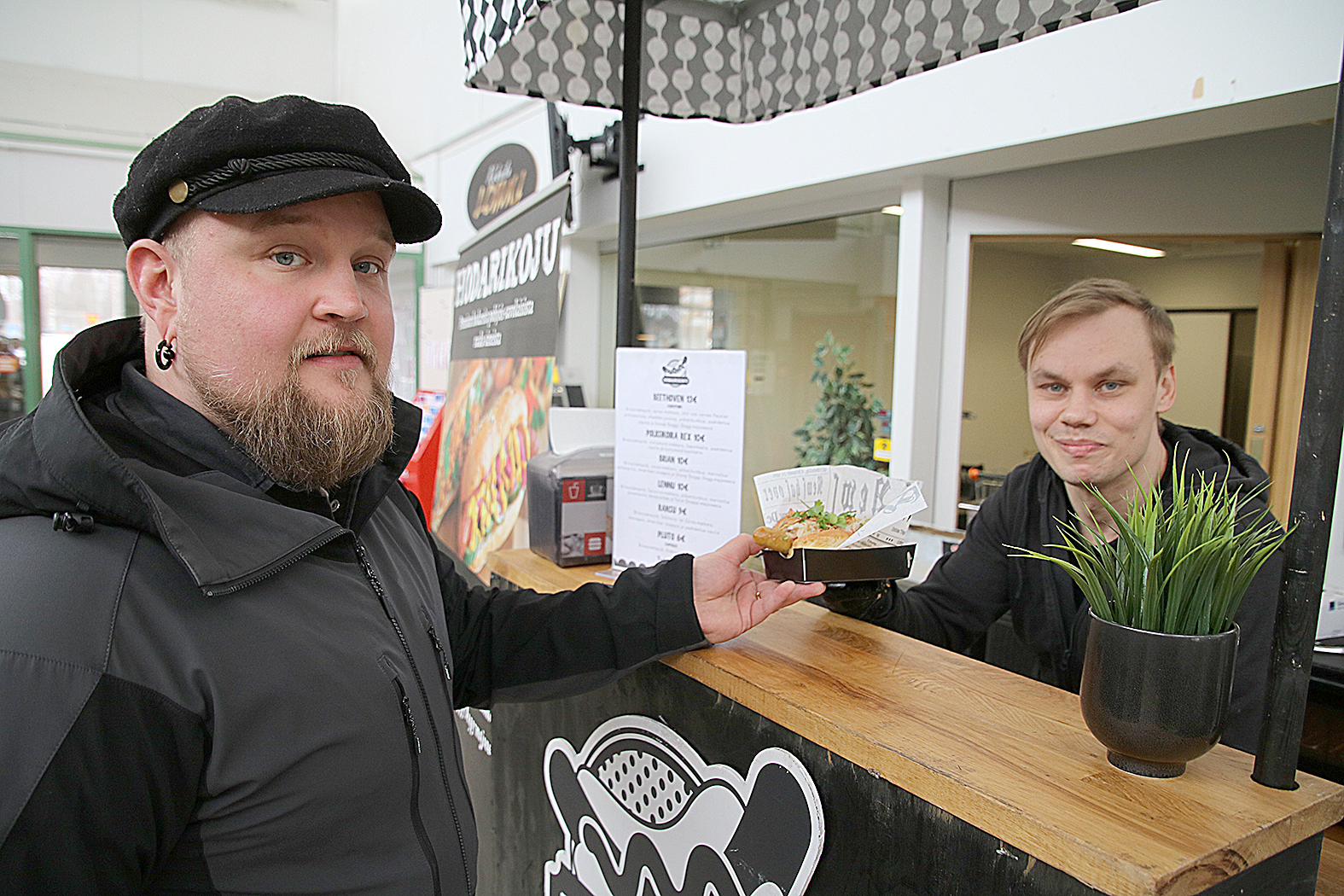 Samuli Riikonen (vas.) on tykästynyt Johannes Tepon valmistamiin hot dogeihin. Riikonen osti tällä kertaa hot dogin nimeltä Poliisikoira Rex.