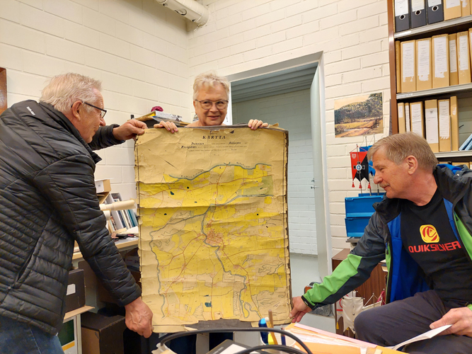 Hannu Päivinen (vas.), Marja Åhlberg ja Arvi Martikainen tutkivat Heino Honkasen jäämistöstä löytynyttä vanhaa Juuan karttaa.