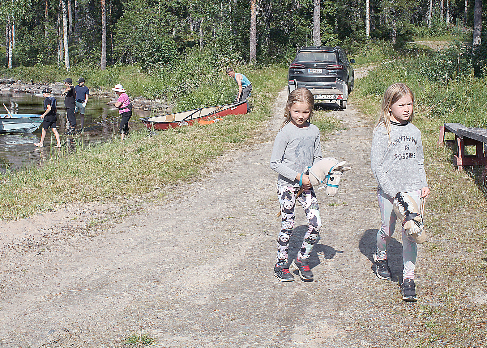 Elli Korhonen (oik.) ja Helmi Hiltunen kerkesivät onkimisen lomassa ratsastamaan keppihevosilla.