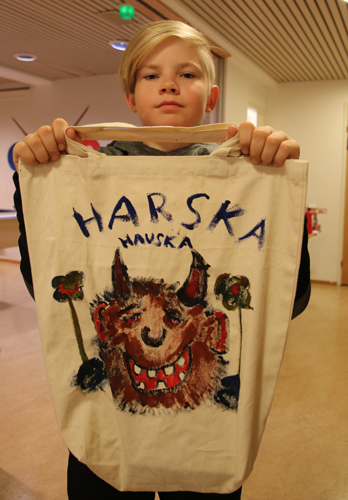 Topi Toivanen esittelee kangaskassiin ideoimaansa kuvaa, jonka etsivä nuorisotyöntekijä Vesa Savolainen lopulta taiteili.