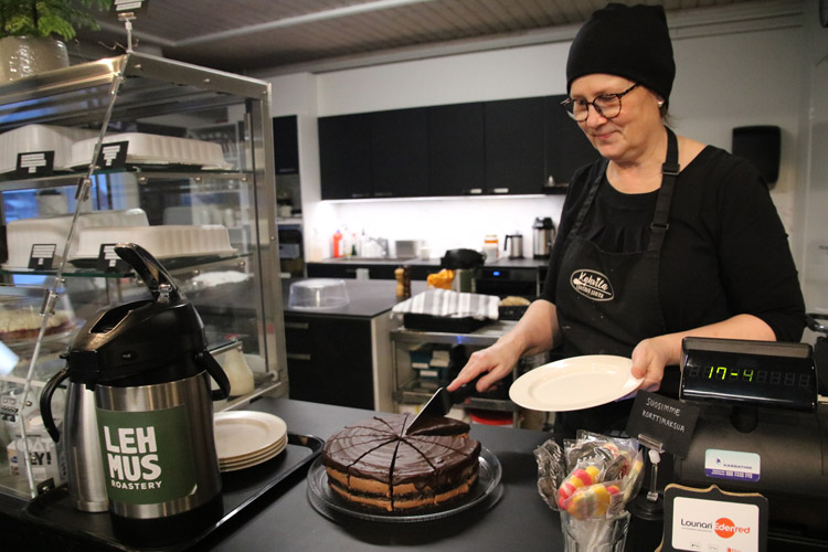Lentävän Luudan yrittäjä Sari Savolainen leikkaa tyttären tekemää suklaakakkua.
