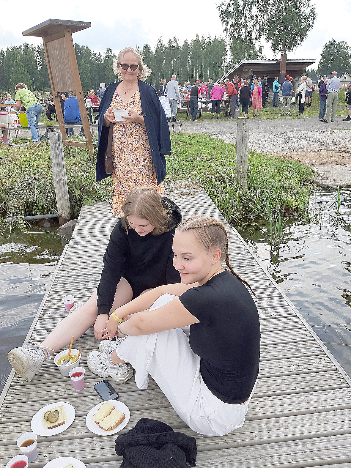 Anne Tossavainen (takana), Moona Sysmäläinen ja Rosa Tossavainen nauttivat kauniista kesäillasta ja muikkukeitosta.