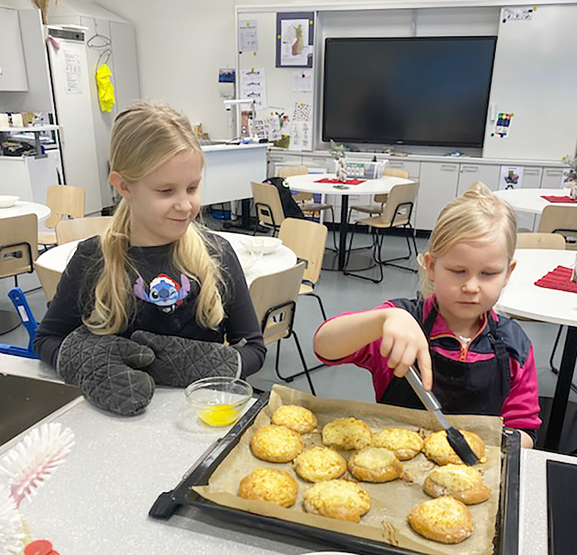 Lilja Hyttinen ja Lumi Hyttinen ihailevat paistettuja riisipyöröjä.