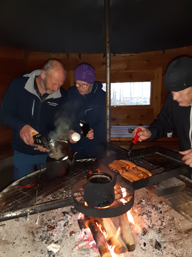 Pentti Kallinen (oik.) paistoi makkaroita ja Jani Miettinen ja Kastehelmi Miettinen osallistuivat kahvinkeittoon.